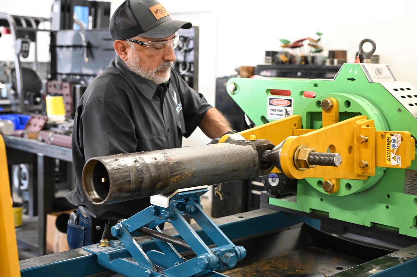 Wilson team member working on a cylinder assembly at the repair press